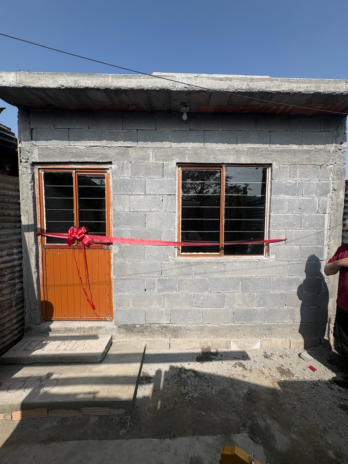 The same family's new home built by Casa De David, ribbon across the door